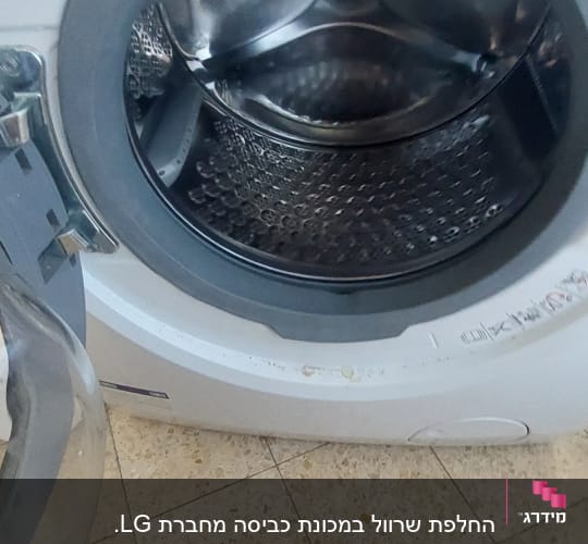 מכונת כביסה פתוחה עם מלקחיים על הרצפה